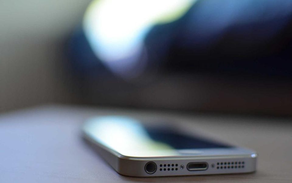 Ein Smartphone liegt auf einem Schreibtisch